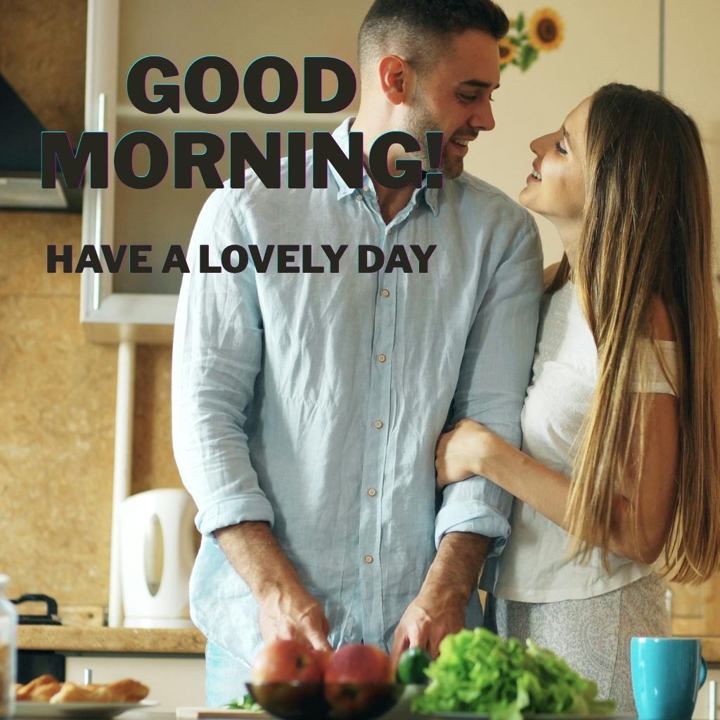 Happy couple smiling at each other in a bright kitchen with fresh fruits and vegetables, overlaid with the text “GOOD MORNING! HAVE A LOVELY DAY.”
