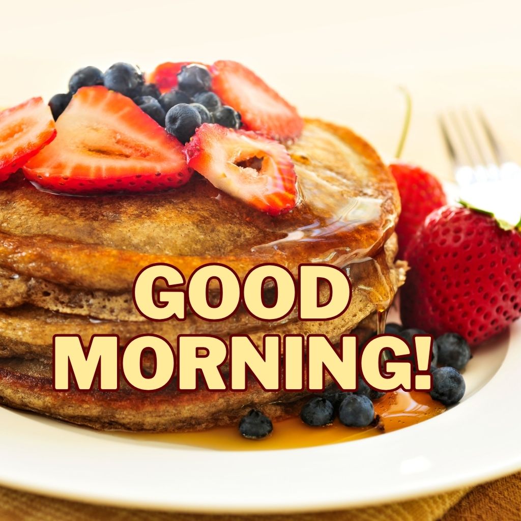 A stack of pancakes topped with strawberries, blueberries, and syrup with bold text reading "GOOD MORNING!" across the bottom.