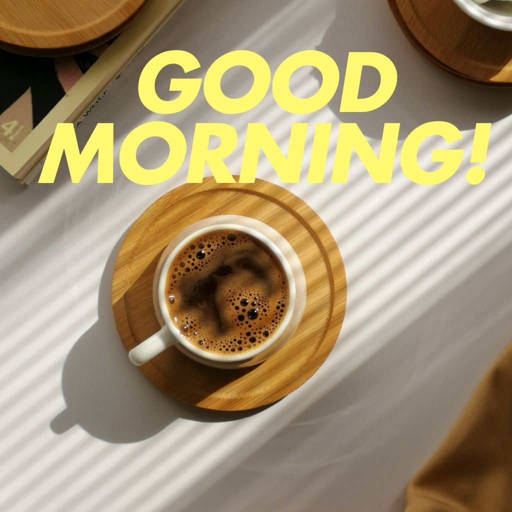 A coffee cup with a "Good Morning" text printed on it, set against a soft, warm background.