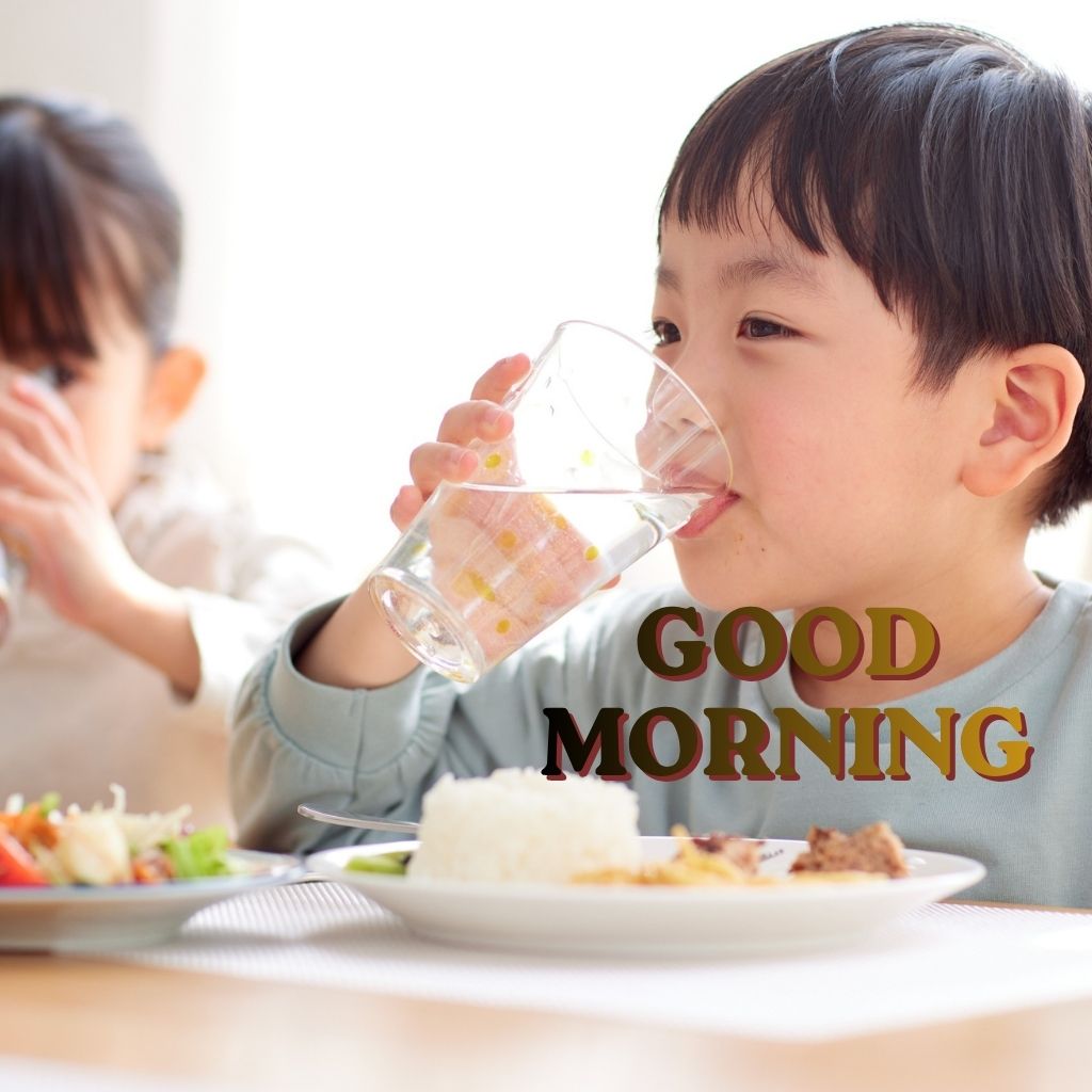 Two children smiling while drinking water from glasses, with "Good Morning" text displayed above them.